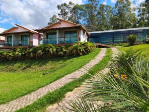 a house on a grassy hill with a building at Pousada do Altar in Conceição do Mato Dentro
