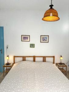 a bedroom with a large bed and two tables with lamps at Blue Sea in Ierapetra