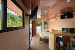 a tiny house with a kitchen and a dining room at Good Vibes Apartments in Talamanca