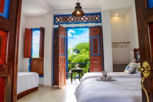 a bedroom with two beds and a large window at Balsora Hotel Boutique in La Tebaida