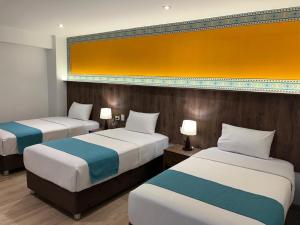 a hotel room with two beds and two lamps at Hanaqua Cusco Hotel in Cusco