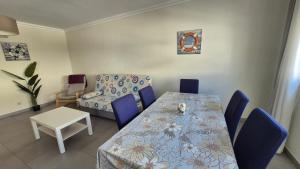 a dining room with a table and blue chairs at Apartamentos Pátio da Aldeia in Armação de Pêra