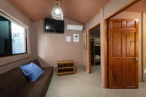 a living room with a couch and a flat screen tv at Good Vibes Apartments in Talamanca