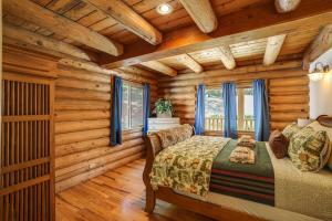 a log cabin bedroom with a bed and windows at Walk to Pine Mountain Lake: Spacious Family Cabin in Groveland
