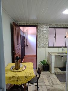 a kitchen with a yellow table and chairs in a room at Espaço aconchegante ótima localização in Foz do Iguaçu