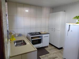 a small kitchen with a stove and a sink at Espaço aconchegante ótima localização in Foz do Iguaçu +9 photos