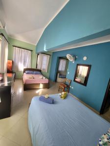 a bedroom with a large bed and a room with two beds at B&B Pavillion in Sosúa