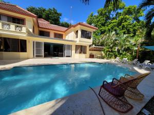 a swimming pool in front of a house at B&B Pavillion in Sosúa