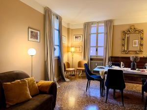 a living room with a couch and a table with chairs at Volto Santo - Sacred Residence - Piazza Maggiore in Bologna