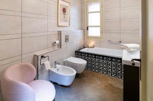 a bathroom with a tub and a toilet and a sink at Volto Santo - Sacred Residence - Piazza Maggiore in Bologna