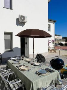 a table with wine glasses and an umbrella at Villa Ibra - Rho Fiera & Milano, Garden & Parking in Paderno Dugnano