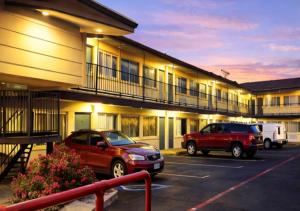 two cars parked in a parking lot in front of a motel at Budget Inn & Suites in Amarillo