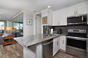 a kitchen with white cabinets and a counter top at Oceanside Cozy Fun and Resortsy Getaway in Oceanside