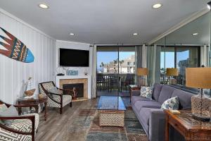 a living room with a couch and a tv at Oceanside Cozy Fun and Resortsy Getaway in Oceanside +11 photos