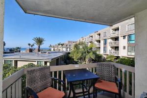 a balcony with a table and chairs and a view of the beach at Oceanside Cozy Fun and Resortsy Getaway in Oceanside