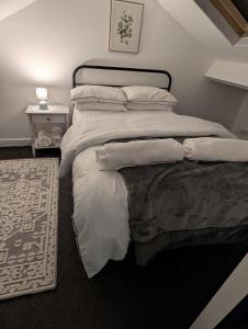 a bedroom with a large bed with white sheets and pillows at Entire Home in Denton in Denton +6 photos