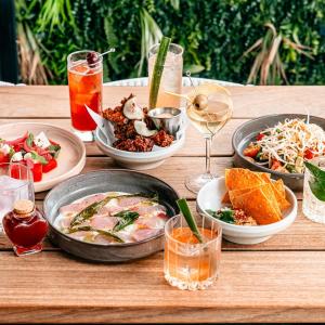 a wooden table topped with plates of food and drinks at Waterfront Wonder + Cp! in Auckland