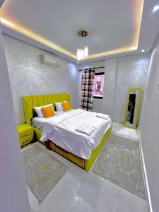 a bedroom with a yellow bed and a window at Oasis Gueliz Center Marrakech in Marrakesh
