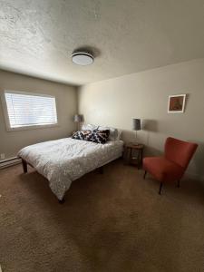 a bedroom with a bed and a red chair at Miller Cabin in McCall