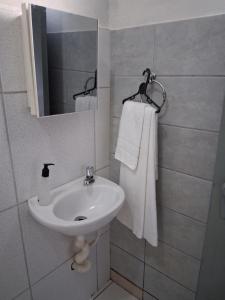 a bathroom with a sink and a mirror and towels at Pousada Cantinho da Idná in Uberlândia +19 photos