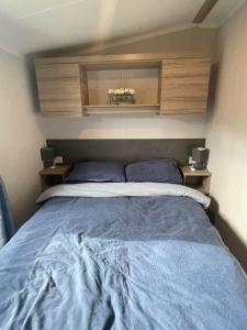 a bedroom with a large bed with blue sheets at Polls Place in Caernarfon +3 photos