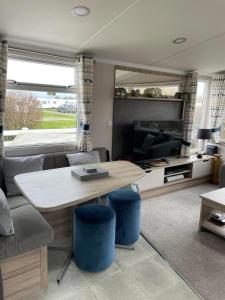 a living room with a table and a couch at Polls Place in Caernarfon