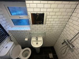 a bathroom with a toilet and a sink and a urinal at Mundesley Cosy cottage in Mundesley