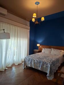 a bedroom with a bed and a blue wall at VersionMoreno apart hotel in General Villegas