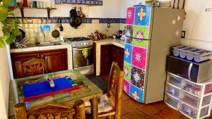 a kitchen with a table and a refrigerator at Hotel Casa Santos Guanajuato in Guanajuato