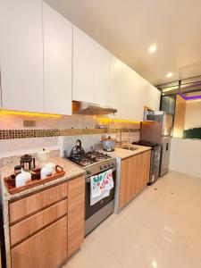 a kitchen with white cabinets and a stove top oven at Estancia Dorada in San Ramón