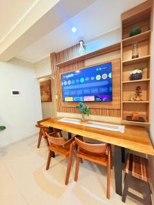 a living room with a wooden table and a tv at Estancia Dorada in San Ramón