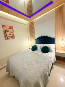 a bedroom with a bed with green pillows on it at Estancia Dorada in San Ramón