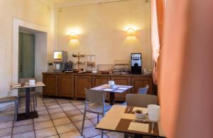 a kitchen with tables and chairs and a counter at Hotel Rossi in Manciano