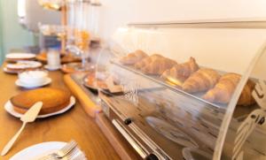 a display case with croissants and bread on a counter at Hotel Rossi in Manciano +45 photos