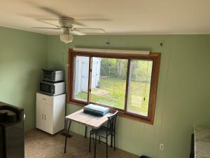 a small kitchen with a table and a window at 3 bed room lake cottage in Geneva
