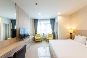 a hotel room with a large bed and a tv at Paeva Luxury By Nakra Functionality in Bang Bo