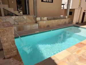 a large swimming pool with blue water in a room at Pousada Bela Flor in São Thomé das Letras