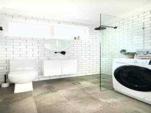 a bathroom with a toilet and a washing machine at Cronulla beach apartments in Cronulla +6 photos