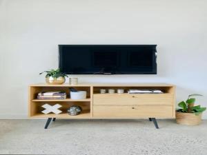 a entertainment center with a tv on a white wall at Cronulla beach apartments in Cronulla