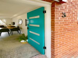 a blue door on the side of a brick wall at Cronulla beach apartments in Cronulla