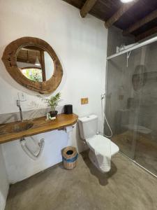 a bathroom with a toilet and a sink and a mirror at Pousada Dendê Caraiva in Caraíva +82 photos