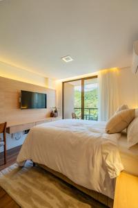 a bedroom with a large bed with a large window at Loft no Granja Brasil Resort, Itaipava centro, Estrutura Completa in Araras Petropolis +100 photos