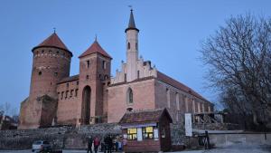 a church with two towers and people standing in front of it at Kamienica Marianna in Reszel