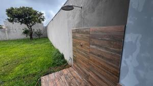 a wooden door on a wall next to a yard at Casa Aparecida in Uberlândia