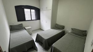 a room with two beds and a window at Casa Aparecida in Uberlândia