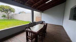 a dining room with a table and chairs and a window at Casa Aparecida in Uberlândia