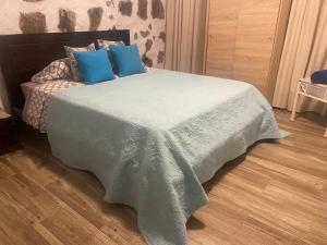 a bedroom with a bed with blue pillows on it at Olive Oasis Adults only in Gran Tarajal
