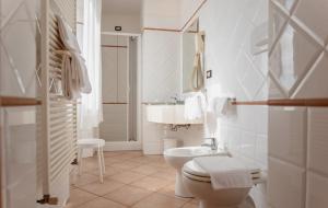 a white bathroom with a sink and a toilet at Hotel Rossi in Manciano