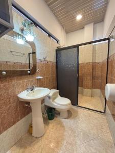 a bathroom with a toilet and a sink and a shower at Casa Raíces "Aire acondicionado, habitaciones familiares y económicas en La Dorada" in La Dorada