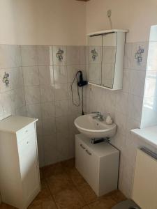 a white bathroom with a sink and a mirror at Ferienwohnung Eble bei Markt Rettenbach in Markt Rettenbach